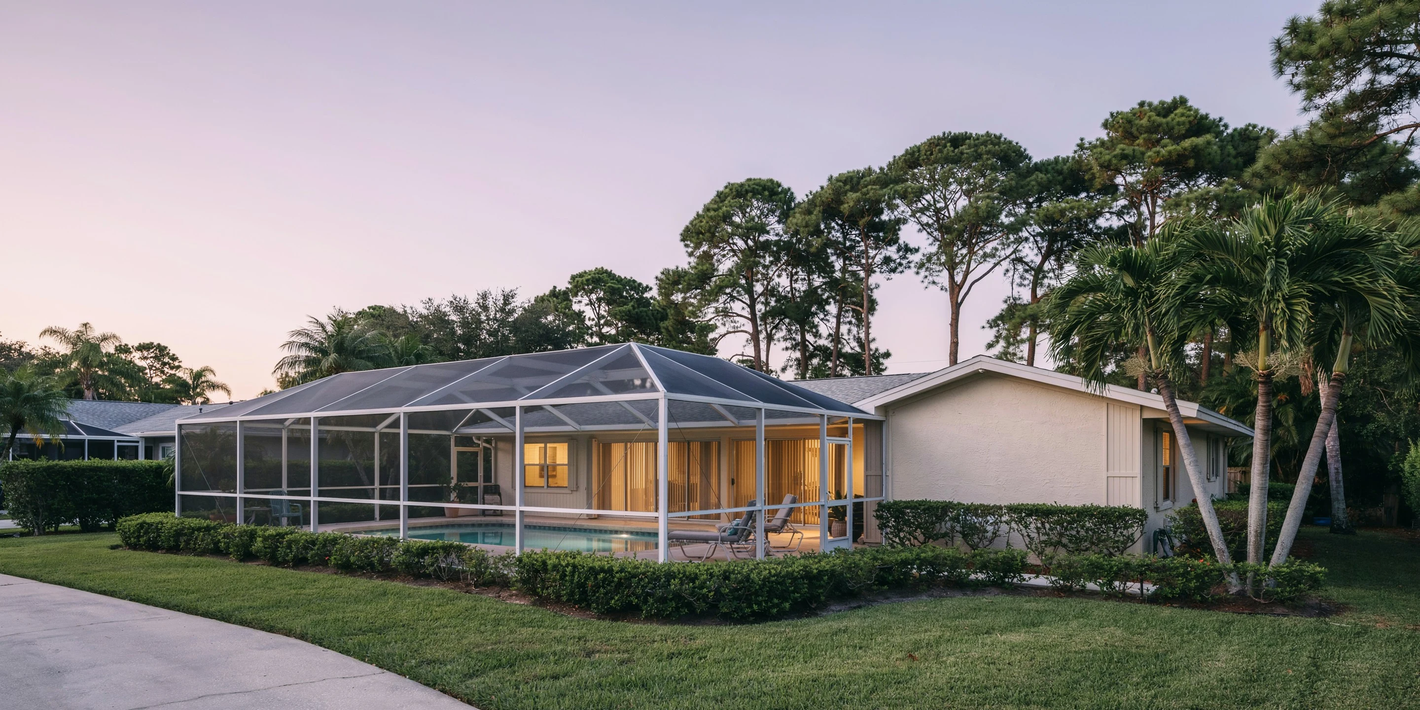 1970s home with pool cage at dusk in Ridgewood, Sarasota, FL