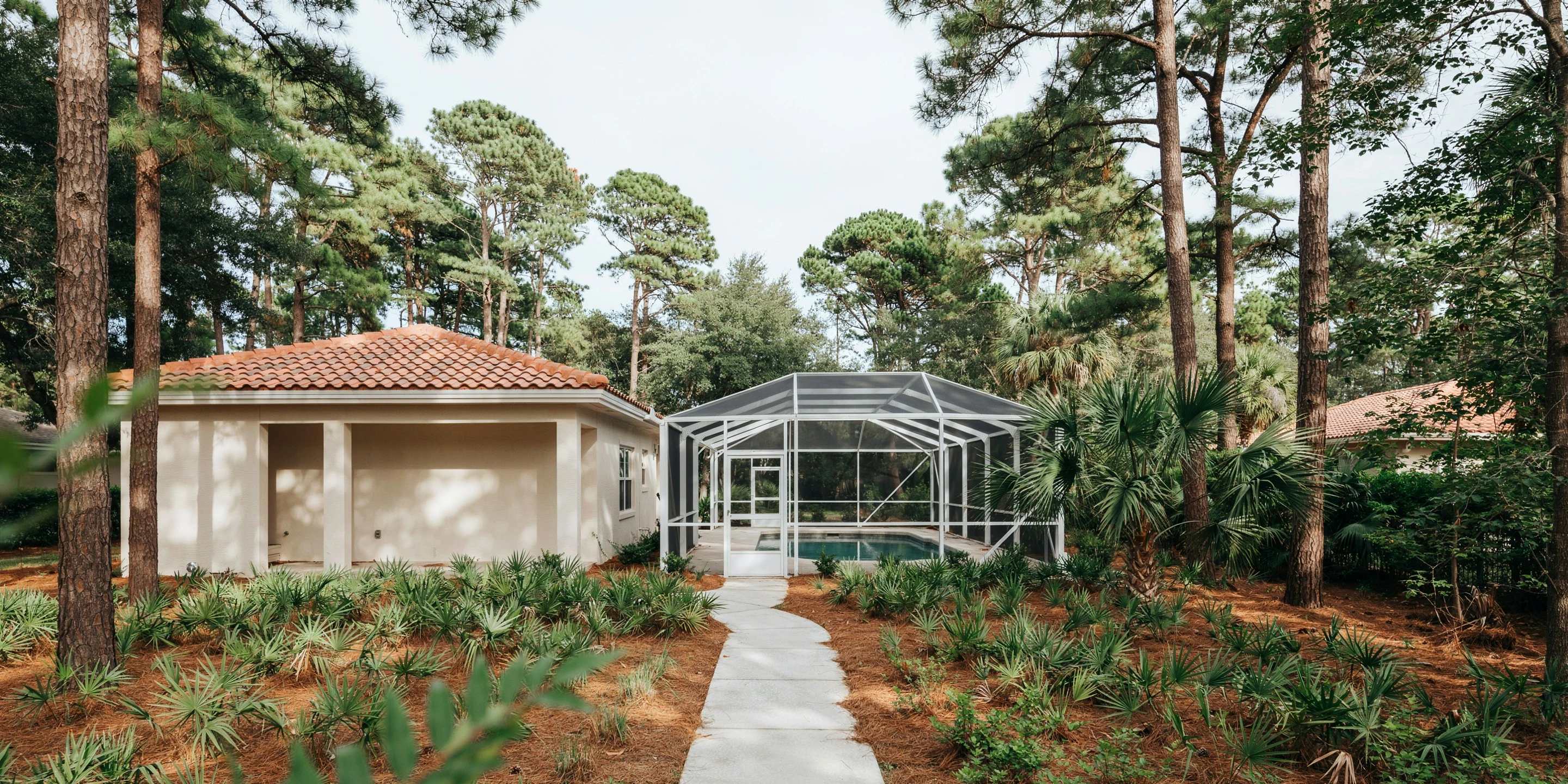 Pool cage tucked among pines in Sherwood Forest, Sarasota, FL